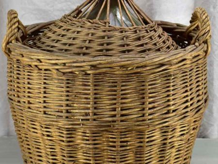 Very large antique French demijohn in a basket For Sale