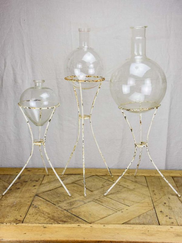 Group of three vintage flasks mounted on iron tripod stands For Sale